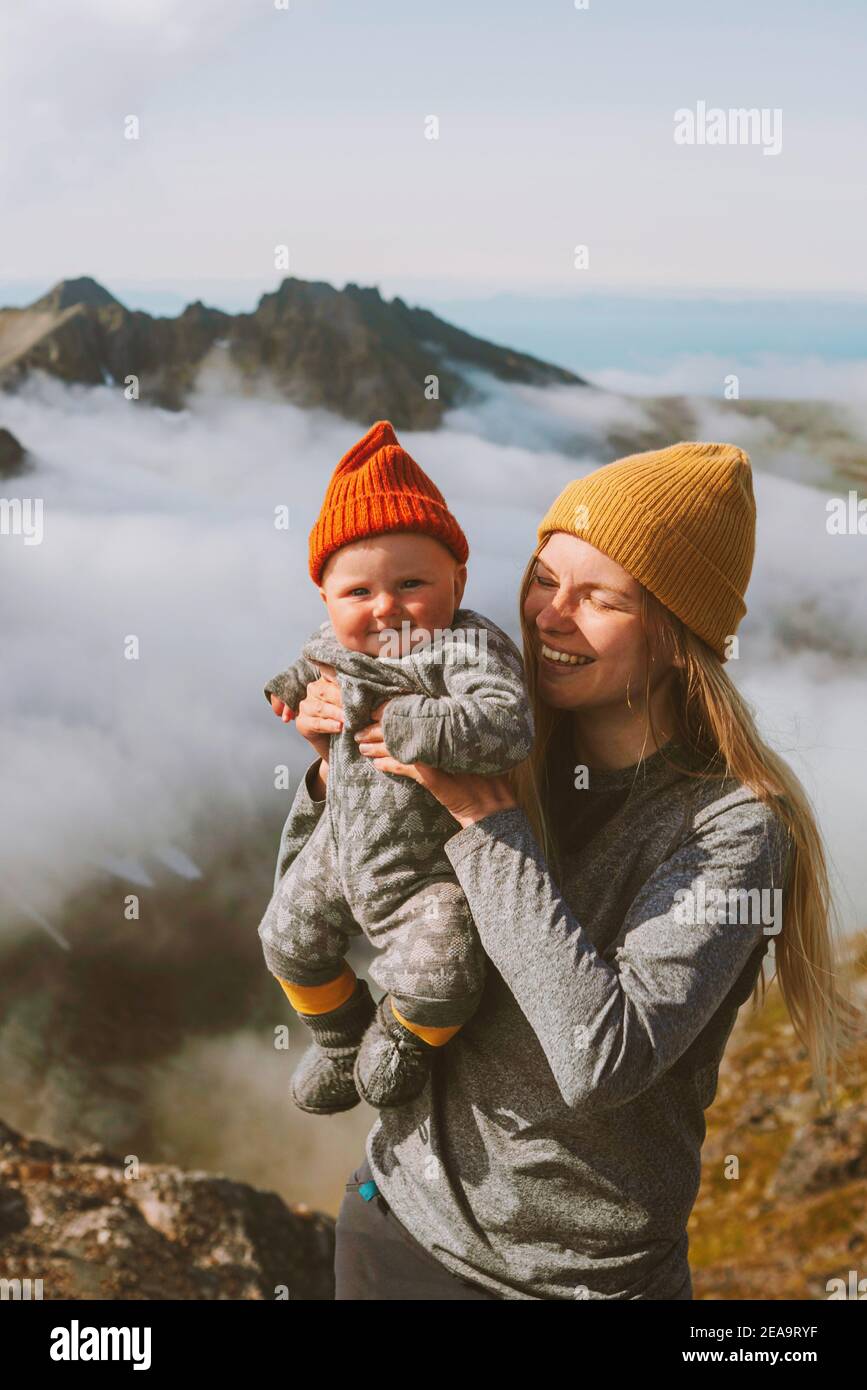 Infant baby with mother traveling in mountains family vacation hiking woman with child active healthy lifestyle tour in Norway Stock Photo