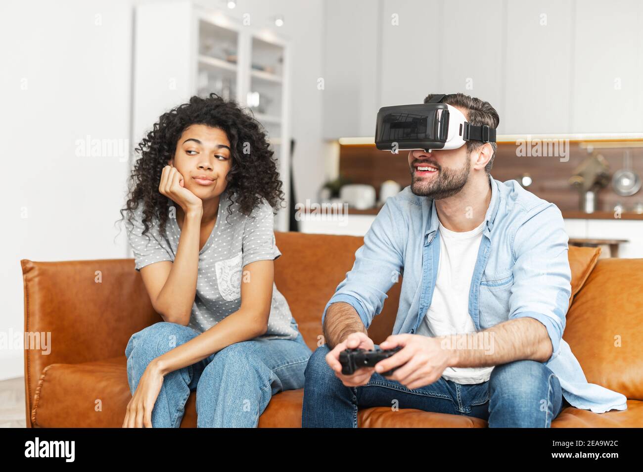 Man Playing Video Games At Home And His Girlfriend Bored Beside Looking At  Him Stock Photo, Picture and Royalty Free Image. Image 52407663.