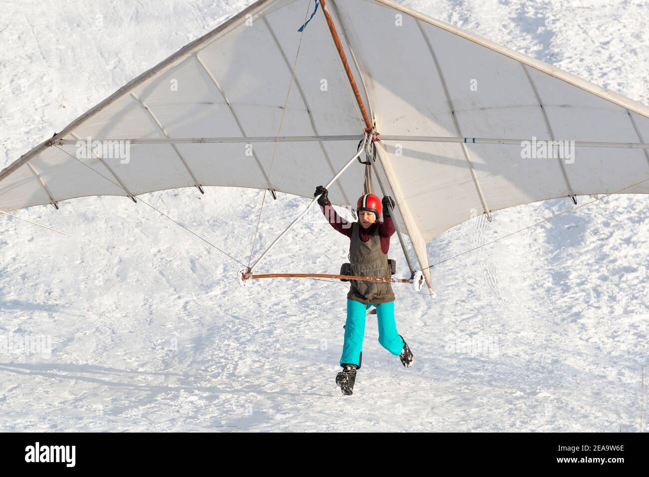 Student girl jumps with a beginner hang glider wing. Learning extreme sports. Stock Photo