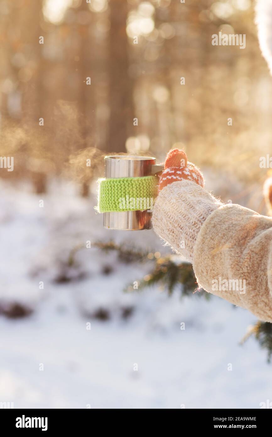 Side view of female hand holding hot cup of coffee or tea in winter Stock Photo