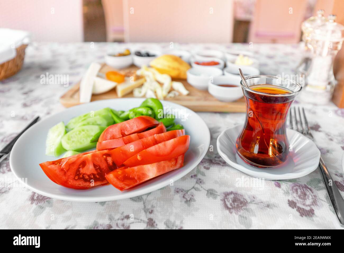 Traditional Turkish glass with strong tea, vegetables and other snacks for a rich middle eastern Breakfast in the outdoor restaurant Stock Photo