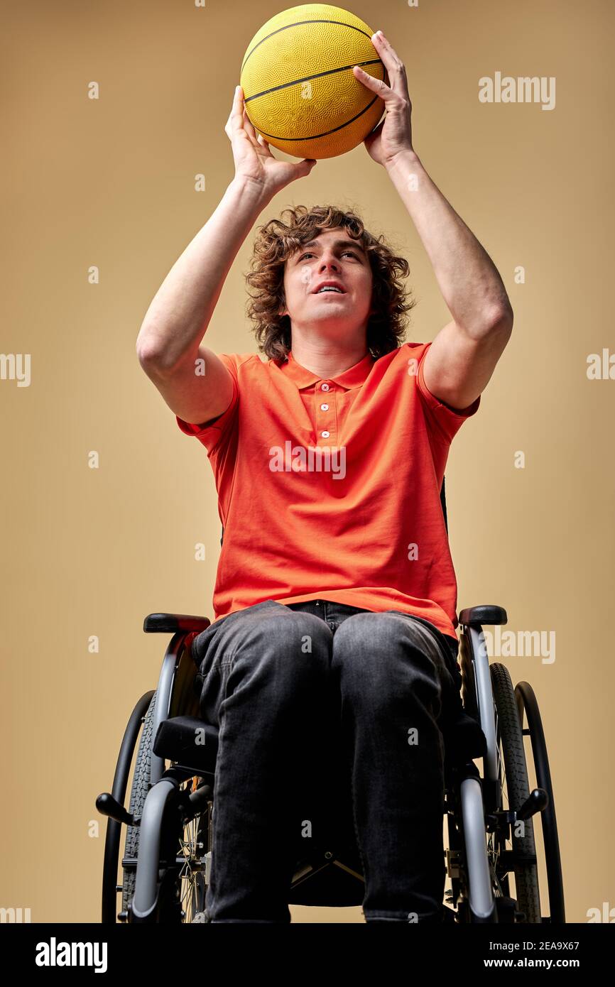 disabled man in wheelchair train with basketball ball, caucasian
