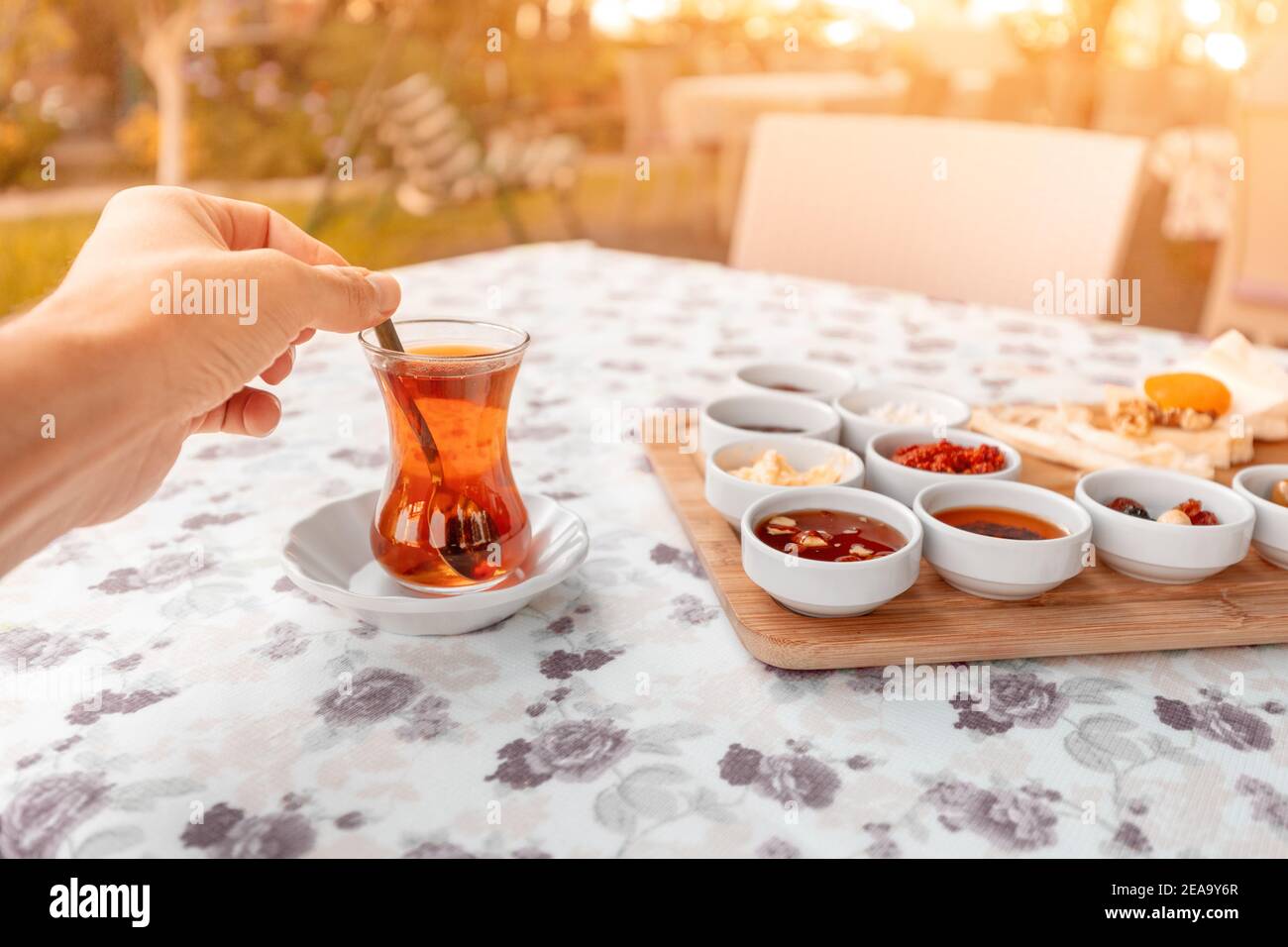 Traditional Turkish glass with strong tea and other snacks for a rich mediterranean Breakfast in the outdoor restaurant Stock Photo
