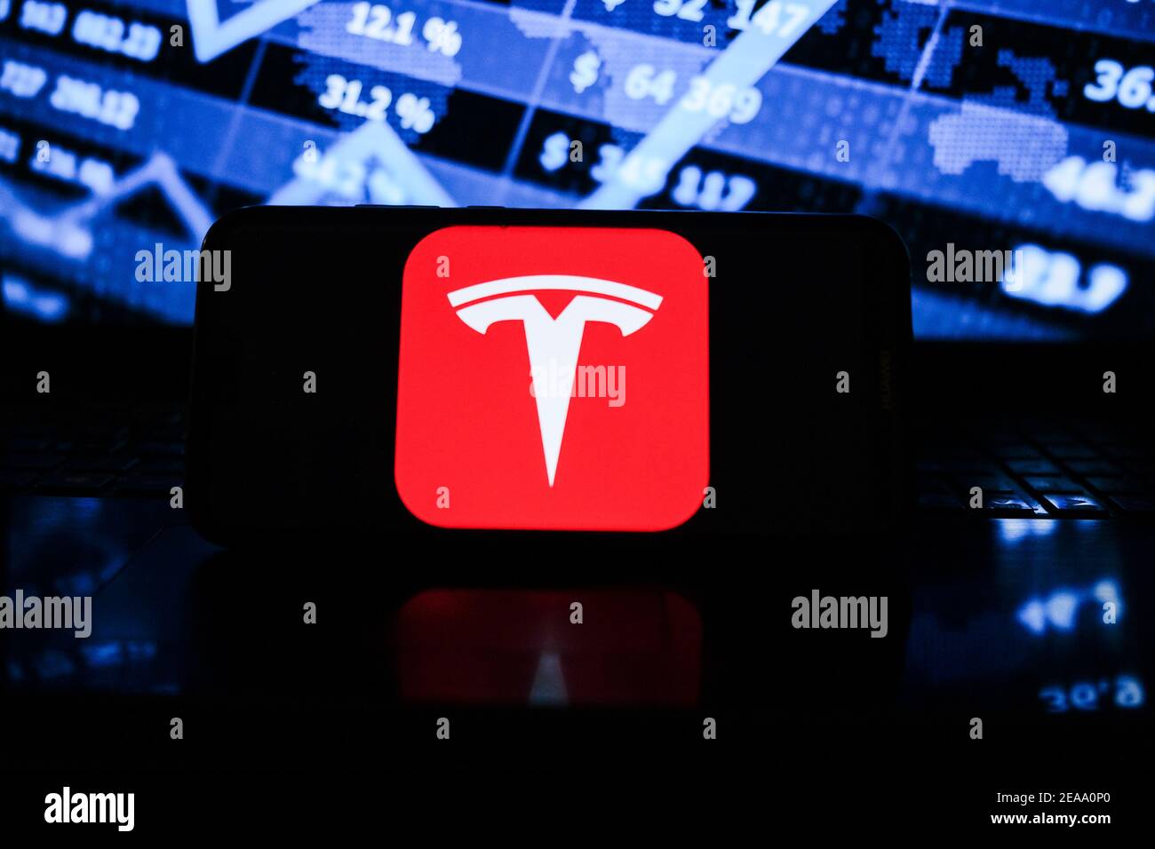In this photo illustration a Tesla logo seen displayed on a smartphone