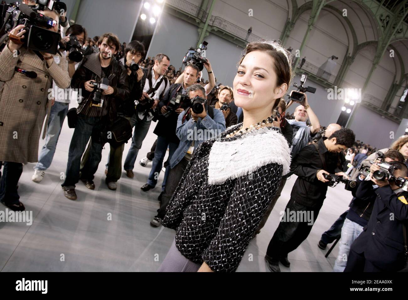 French actress Marion Cotillard with a Chanel umbrella during the Chanel  Ready-to-Wear Spring-Summer 2006 collection presentation, designed by  German fashion designer Karl Lagerfeld, at the 'Grand Palais', in Paris,  France, on October 7, 2005. Photo