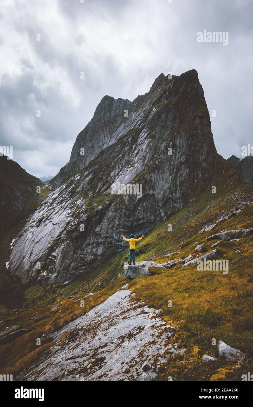 Adventures in mountains man hiker raised hands travel solo extreme vacations in Norway outdoor healthy lifestyle hiking trip Stock Photo