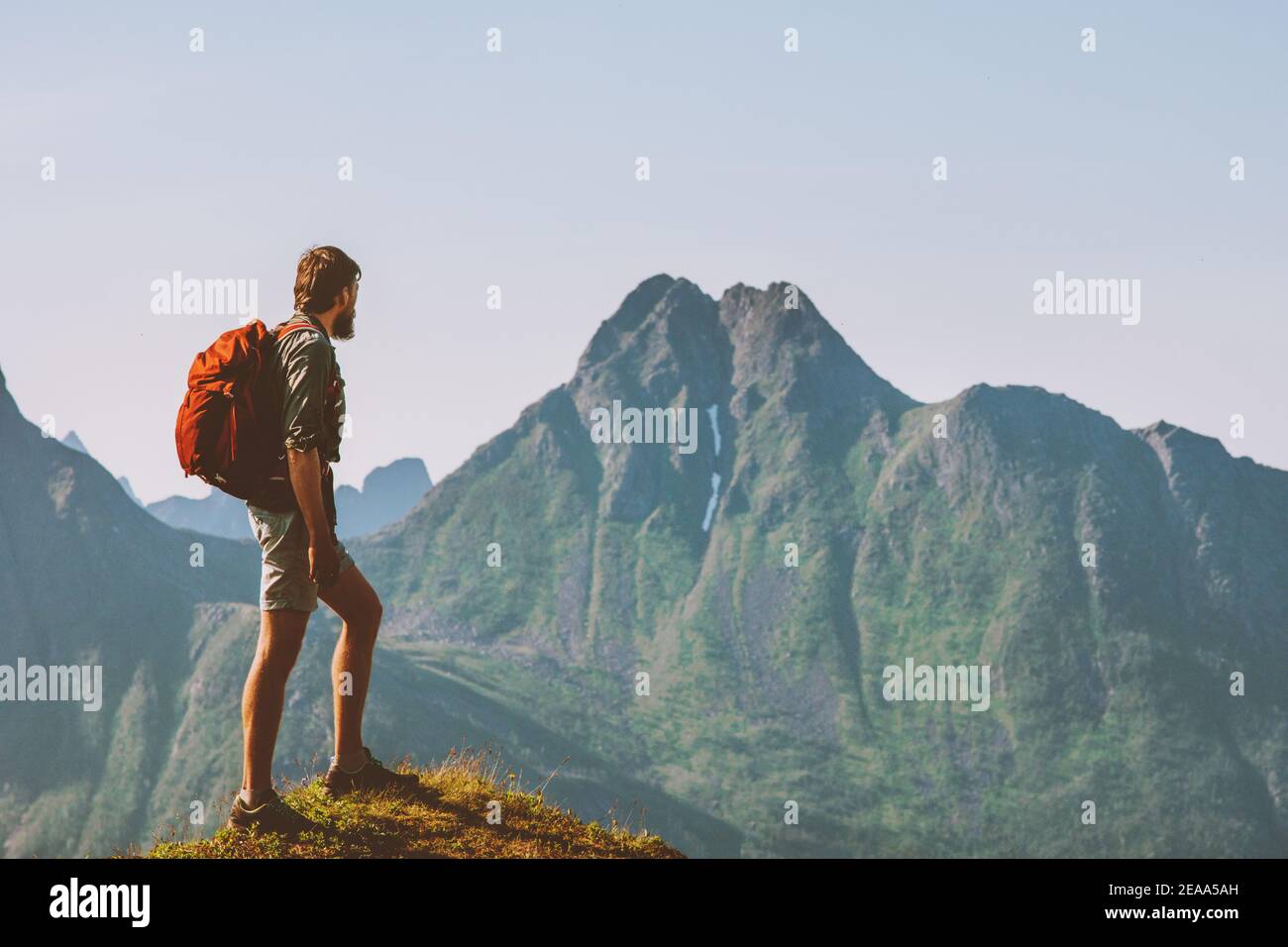 Man hiking with backpack in Norway enjoying mountains view travel adventure vacation outdoor trekking active healthy lifestyle motivation concept Stock Photo