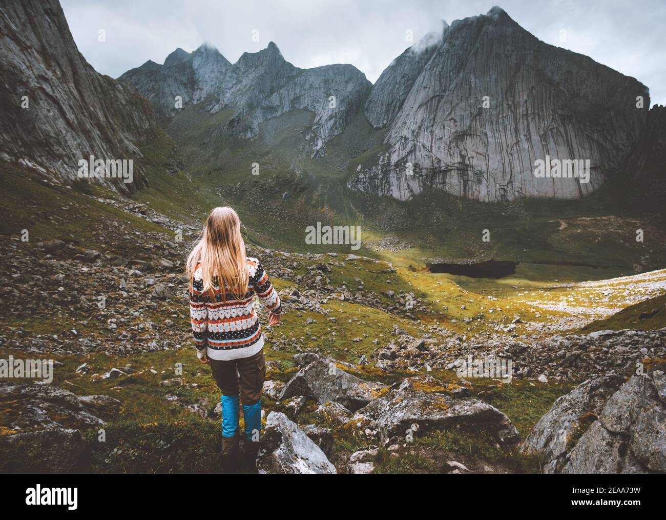 Woman hiking in mountains travel solo in Norway outdoor adventure active healthy lifestyle trip eco tourism trail Lofoten islands Stock Photo