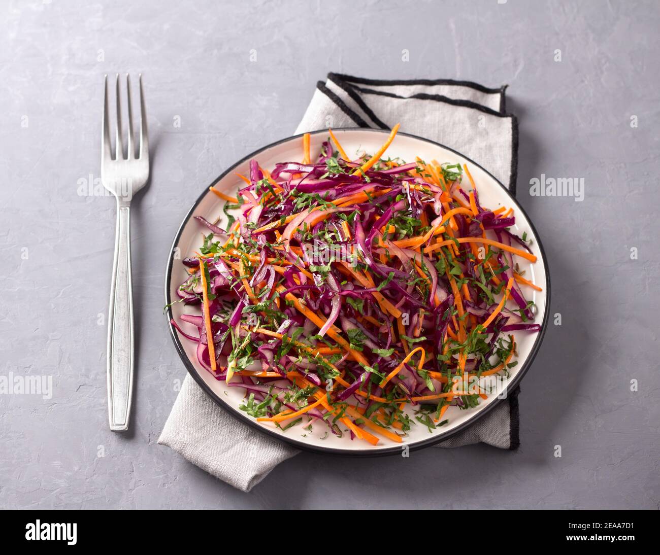 Red cabbage coleslaw salad with cumin and mustard sauce on gray