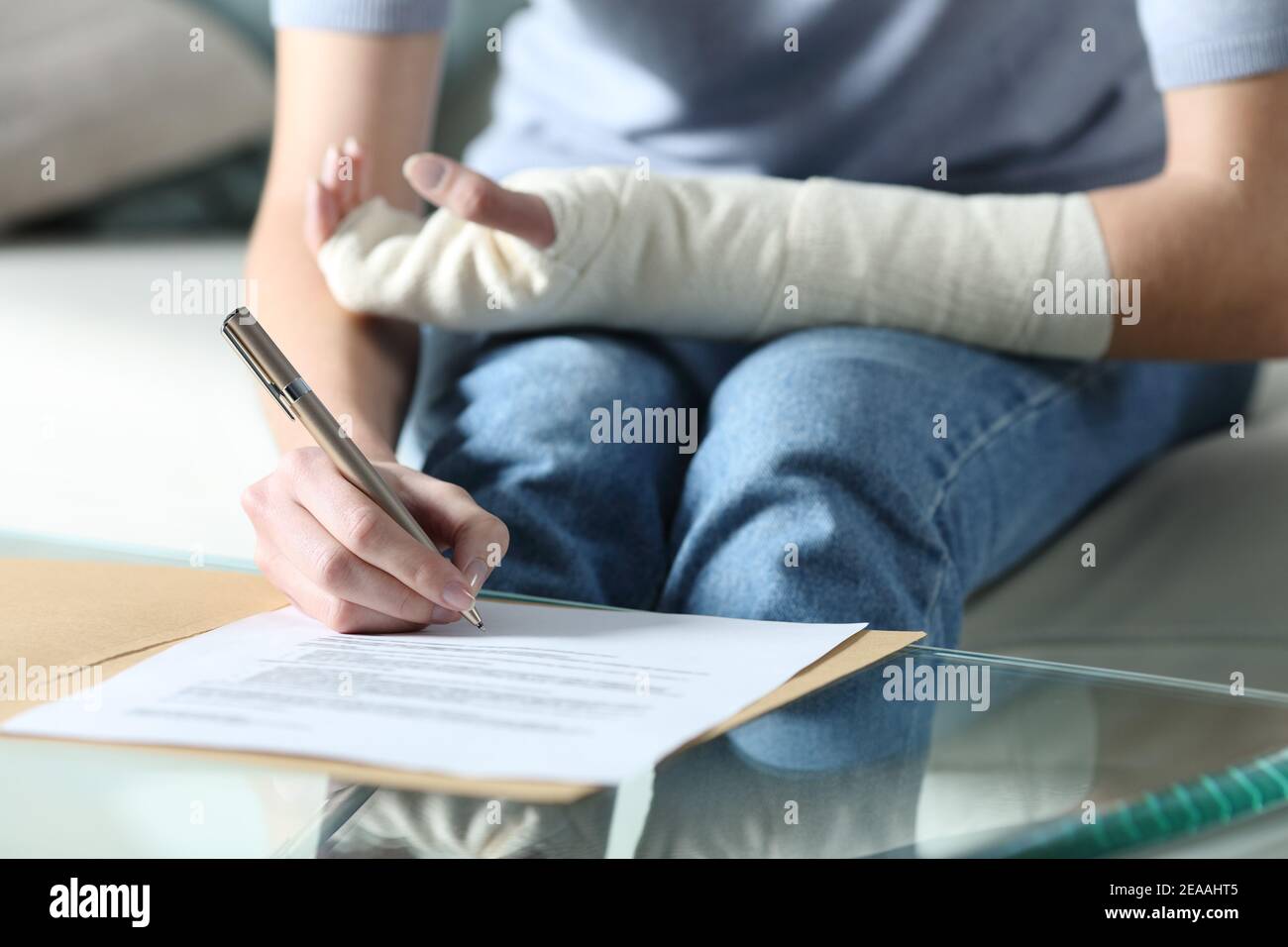 Close up portrait of a disabled woman with bandaged arm sigining insurance document Stock Photo