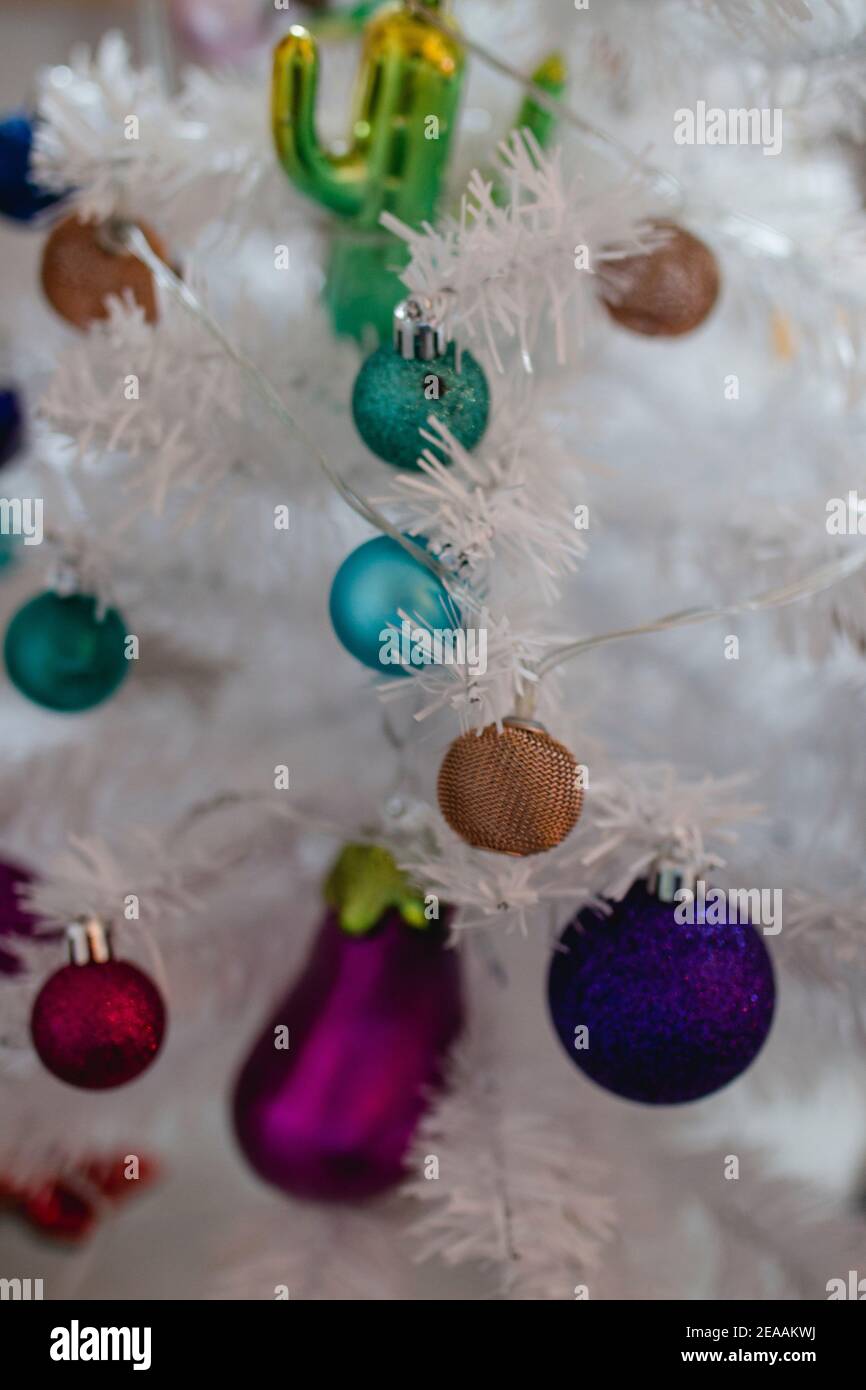 Kitschy plastic Christmas tree in white with colorful balls and pendants Stock Photo