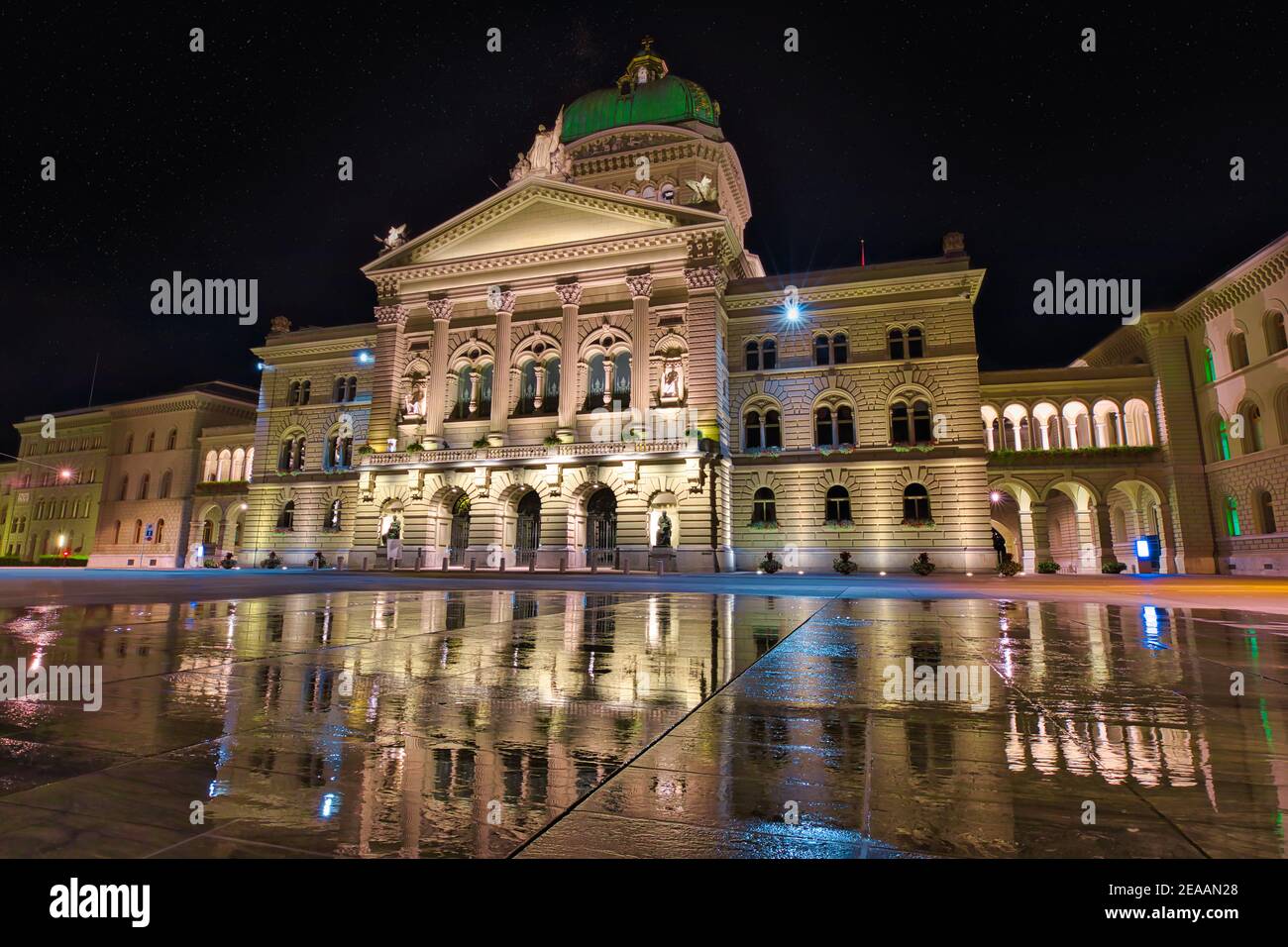 Federal Palace facade in Bern, Switzerland illuminated at night. Swiss Parliament building reflecting in the water in Bundesplatzn. Landmark of Stock Photo