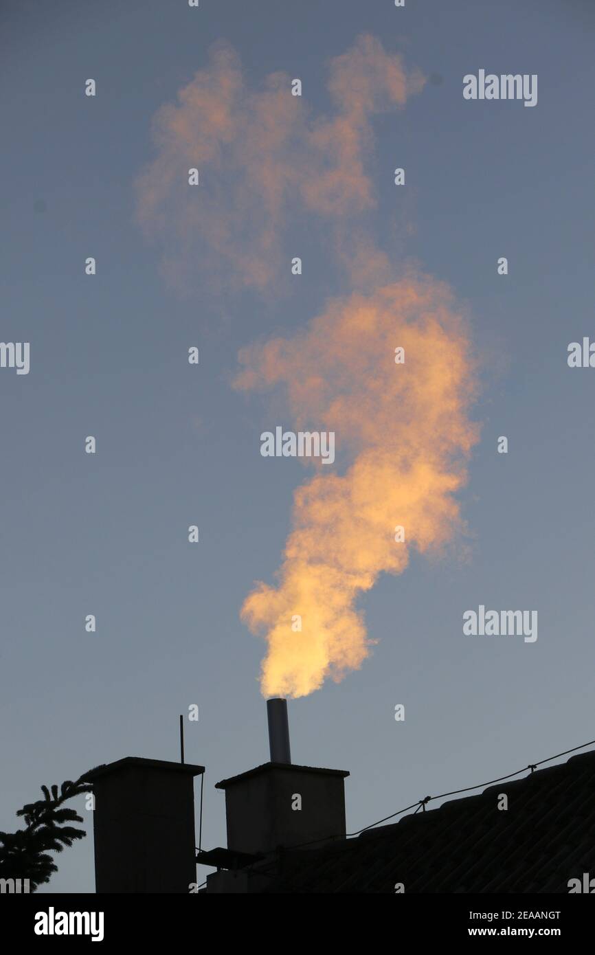 smoking chimney in the morning sun Stock Photo
