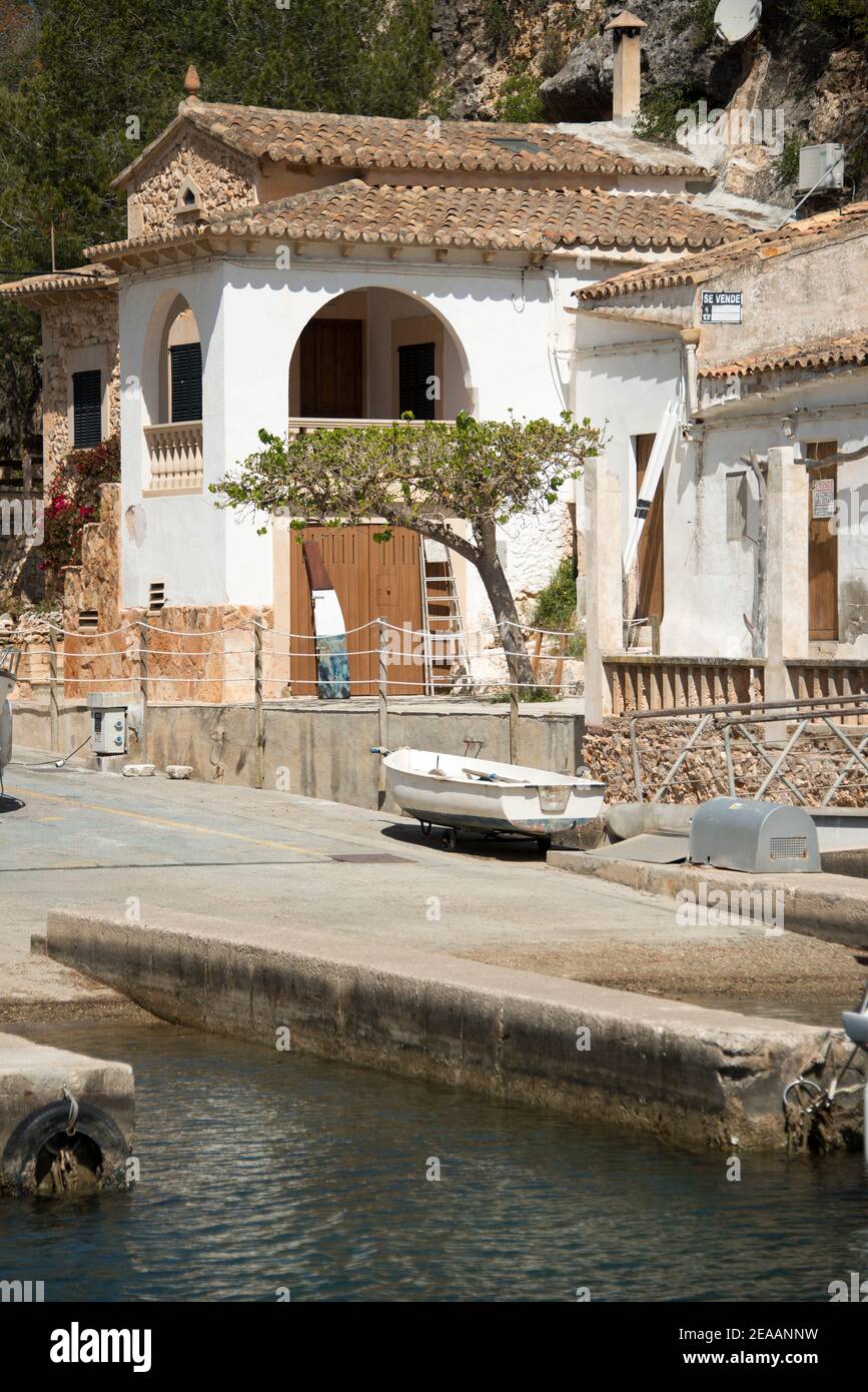 Rocky coast of Cala Llombards, landing stage with house, Mallorca Stock Photo