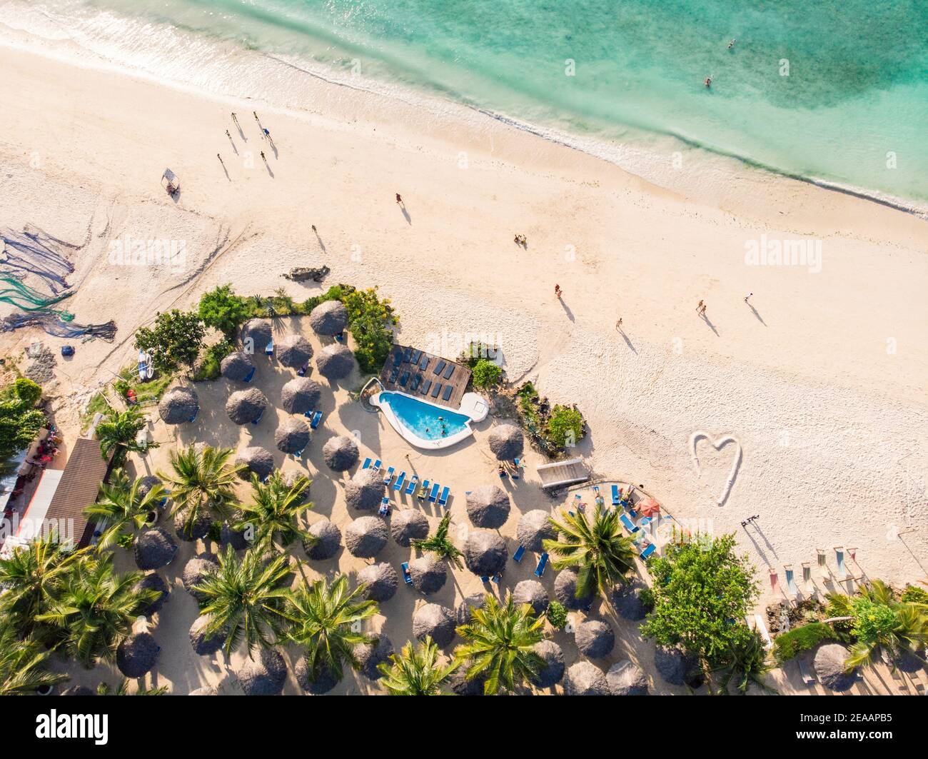 Top Aerial view of Thatched roofed beach umbrellas of luxury ocean view resort at the beautiful white sand ocean coast in Nungwi at Zanzibar island Stock Photo