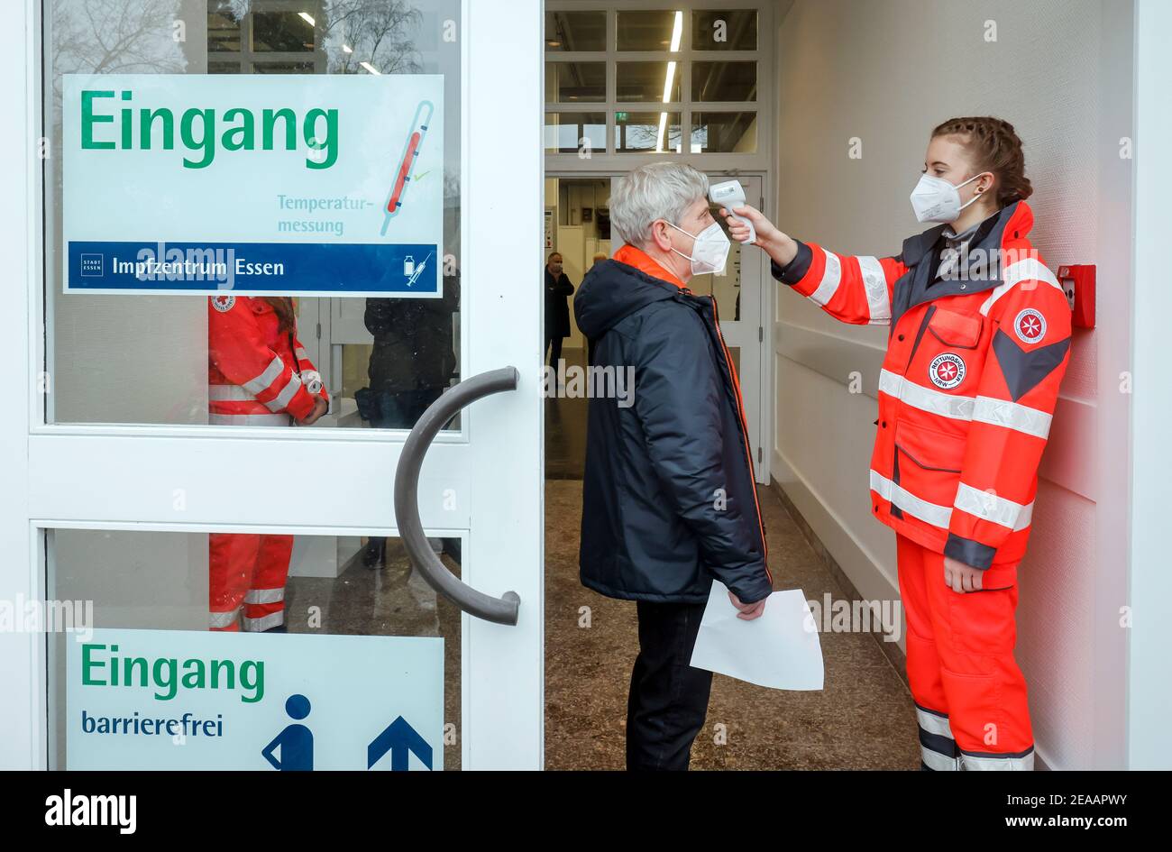 Essen, Ruhr area, North Rhine-Westphalia, Germany - Corona vaccination center Essen in the halls of Messe Essen, here more than 2, 000 people are to be vaccinated per day, during a test run rescue workers measure the temperature of a person being vaccinated (scene with a pensioner as extras). Stock Photo