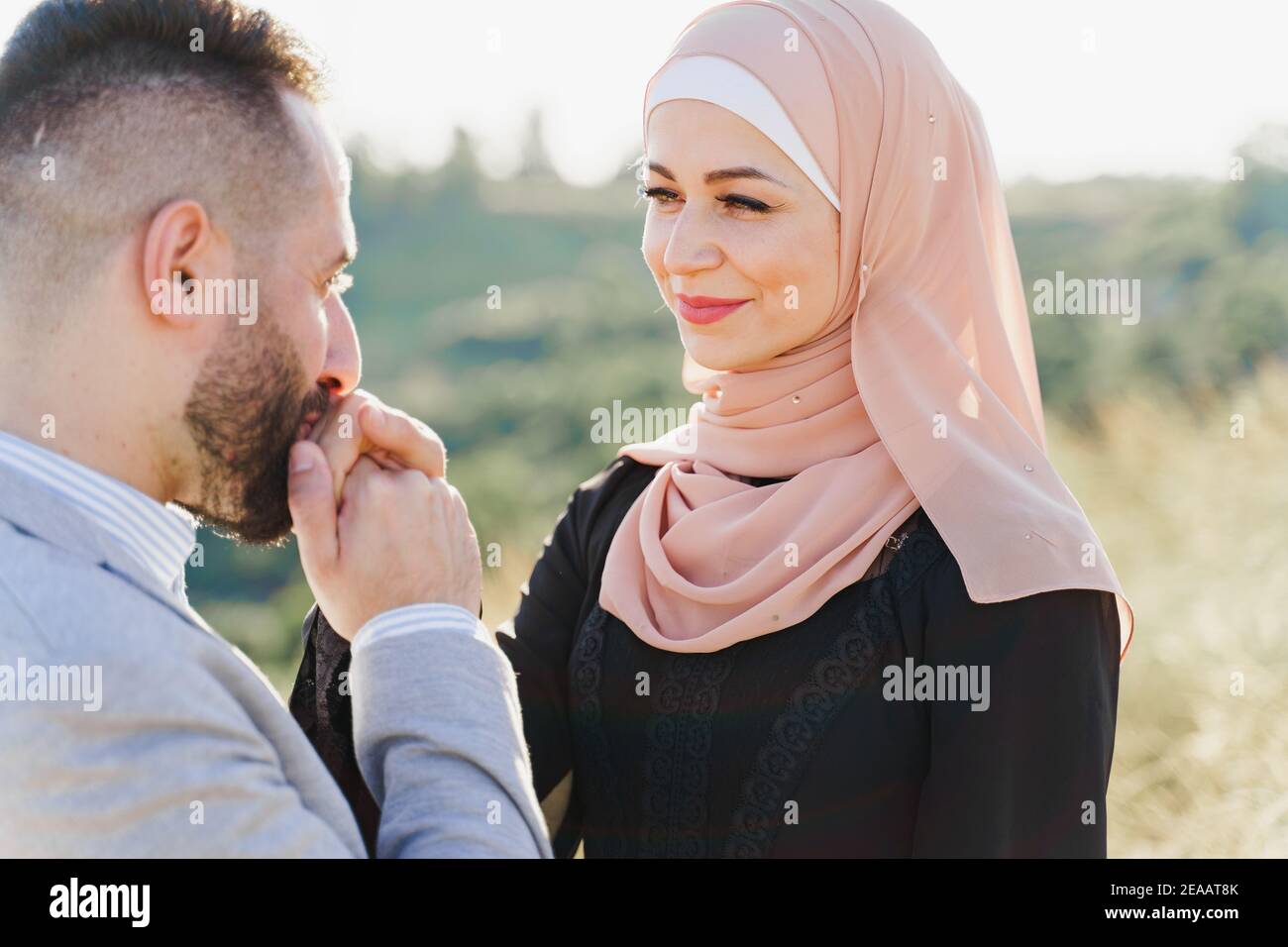 Muslim love story close-up. Mixed couple smiles and hugs on the ...