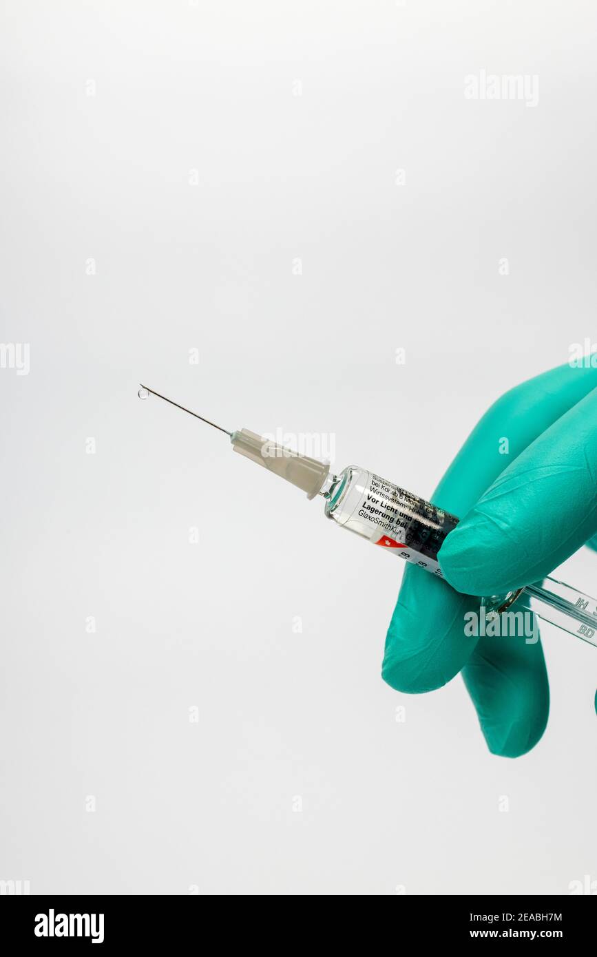 Doctor hand hold flu injection syringe, drop on needle tip, symbol photo, flu vaccination, Stock Photo