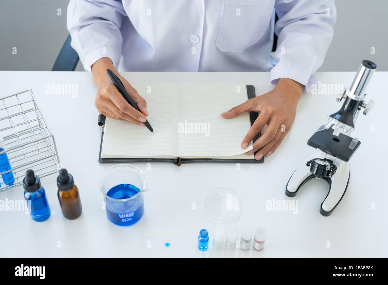 scientists researching in laboratory in white lab coat, gloves