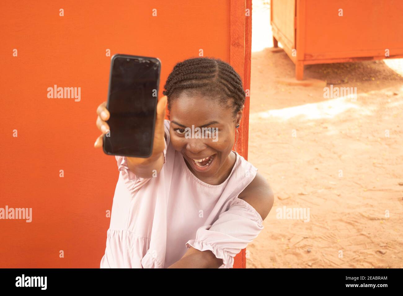 an african lady holding her phone Stock Photo