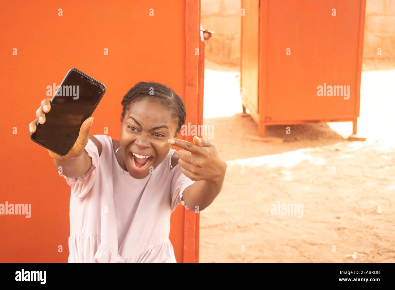 an african lady pointing to her phone Stock Photo