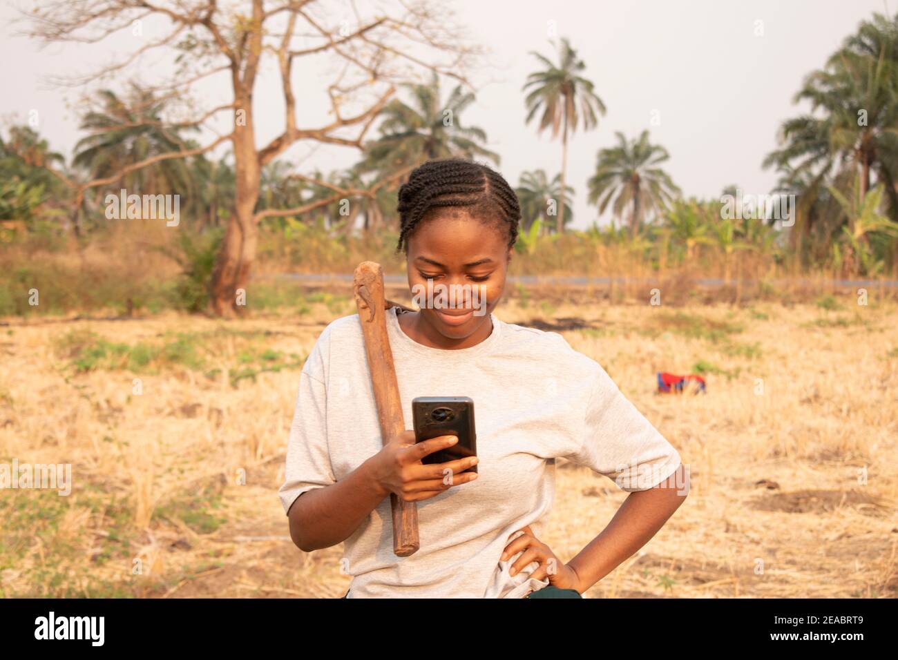an african woman chatting from the farm with her smartphone Stock Photo