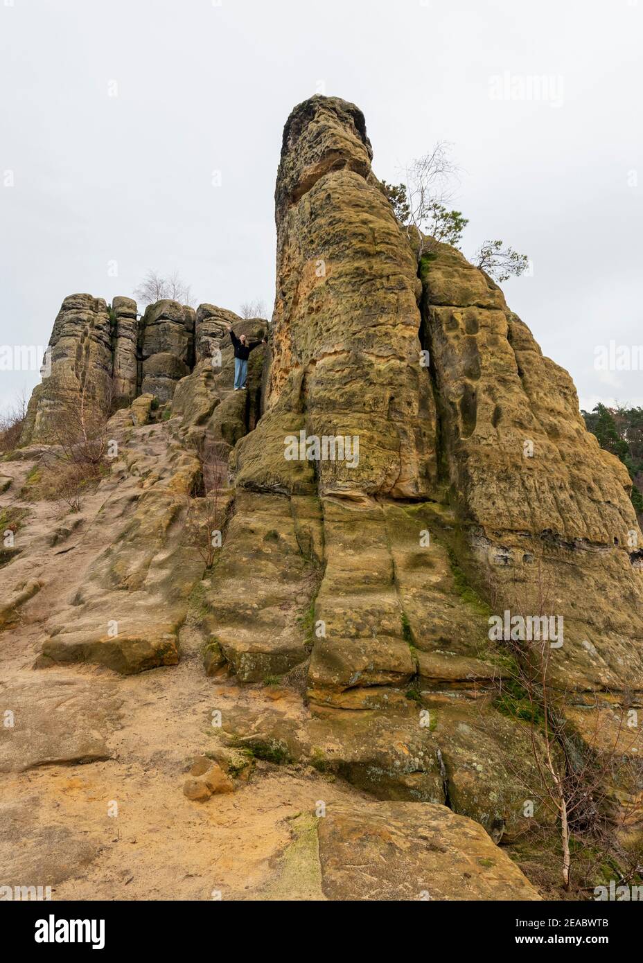 Germany, Saxony-Anhalt, Halberstadt, woman stands on a rock made of sandstone in the Klusberge, mountain range in the Vorharz. Stock Photo