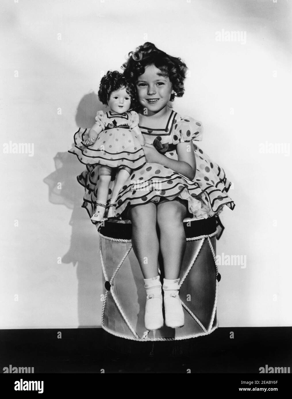 1936 ca. , USA : The child actress  SHIRLEY TEMPLE  with her doll look-a-like , Fox movie pubblicity still   - MOVIE - FILM - CINEMA - portrait - ritratto -  personality personalities actor actors with dolls  - personalità celebrità attori con bambole bambola - cane - polka dots - plkadots - polka-dots - pois  - smile - sorriso   ----  Archivio GBB Stock Photo
