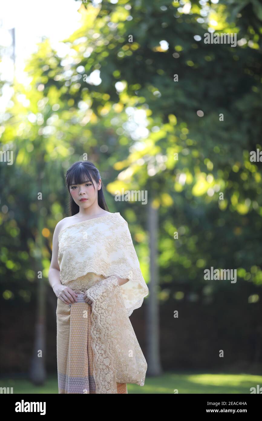 Portrait of Thai female with traditional Thai dress with temple background Stock Photo