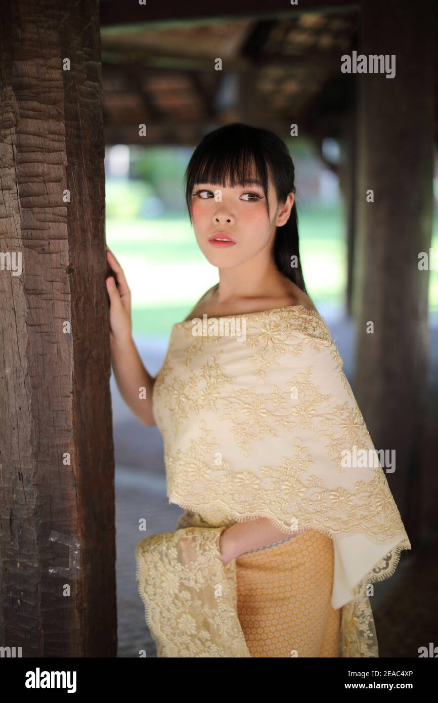 Portrait of Thai female with traditional Thai dress with temple ...