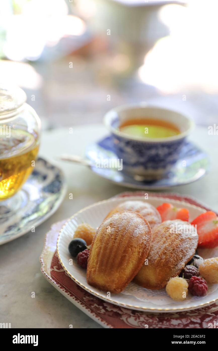 Madeleines , French sweet dessert with fruits and tea Stock Photo