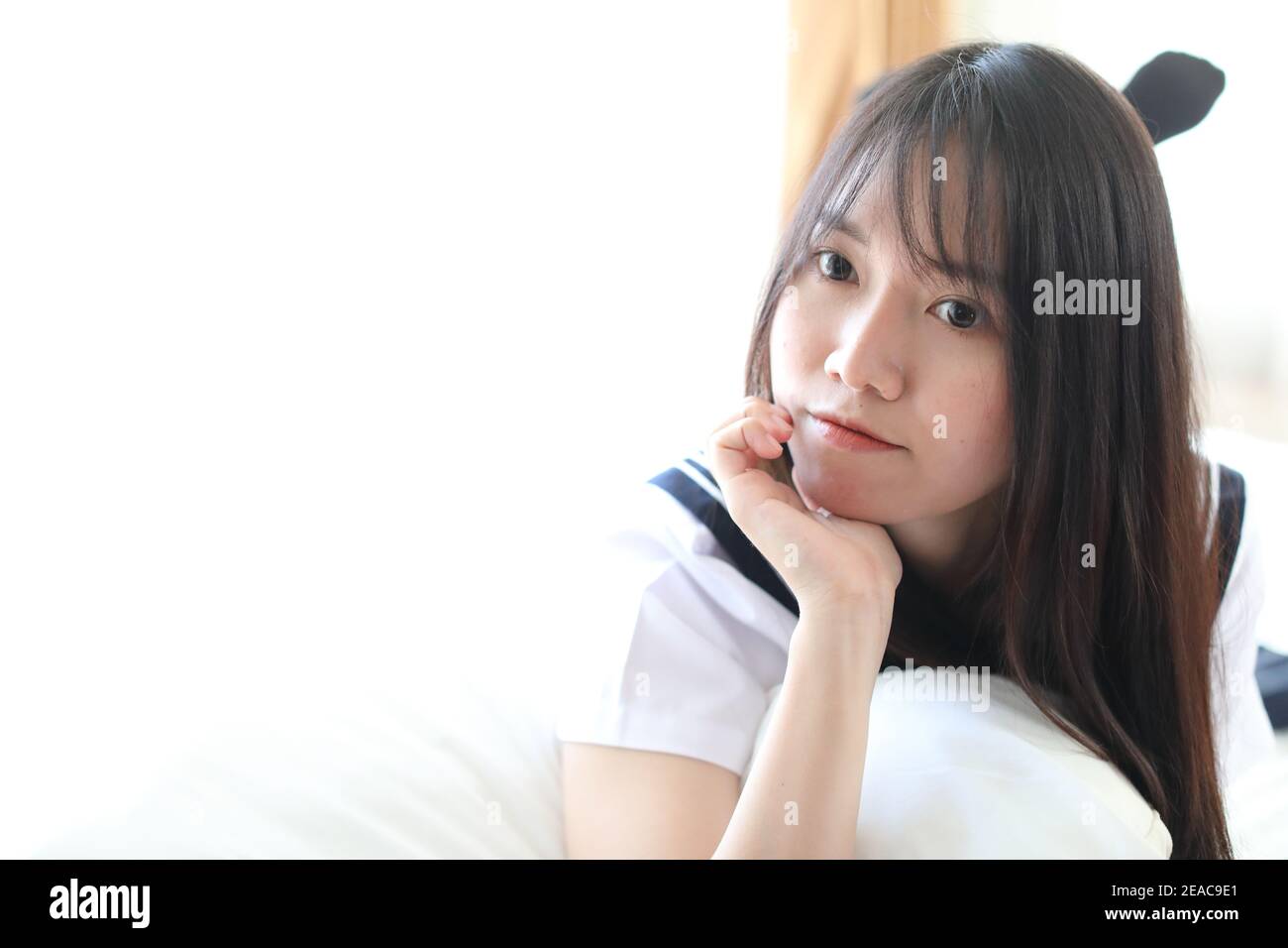 Portrait japanese school girl in white tone bed room Stock Photo