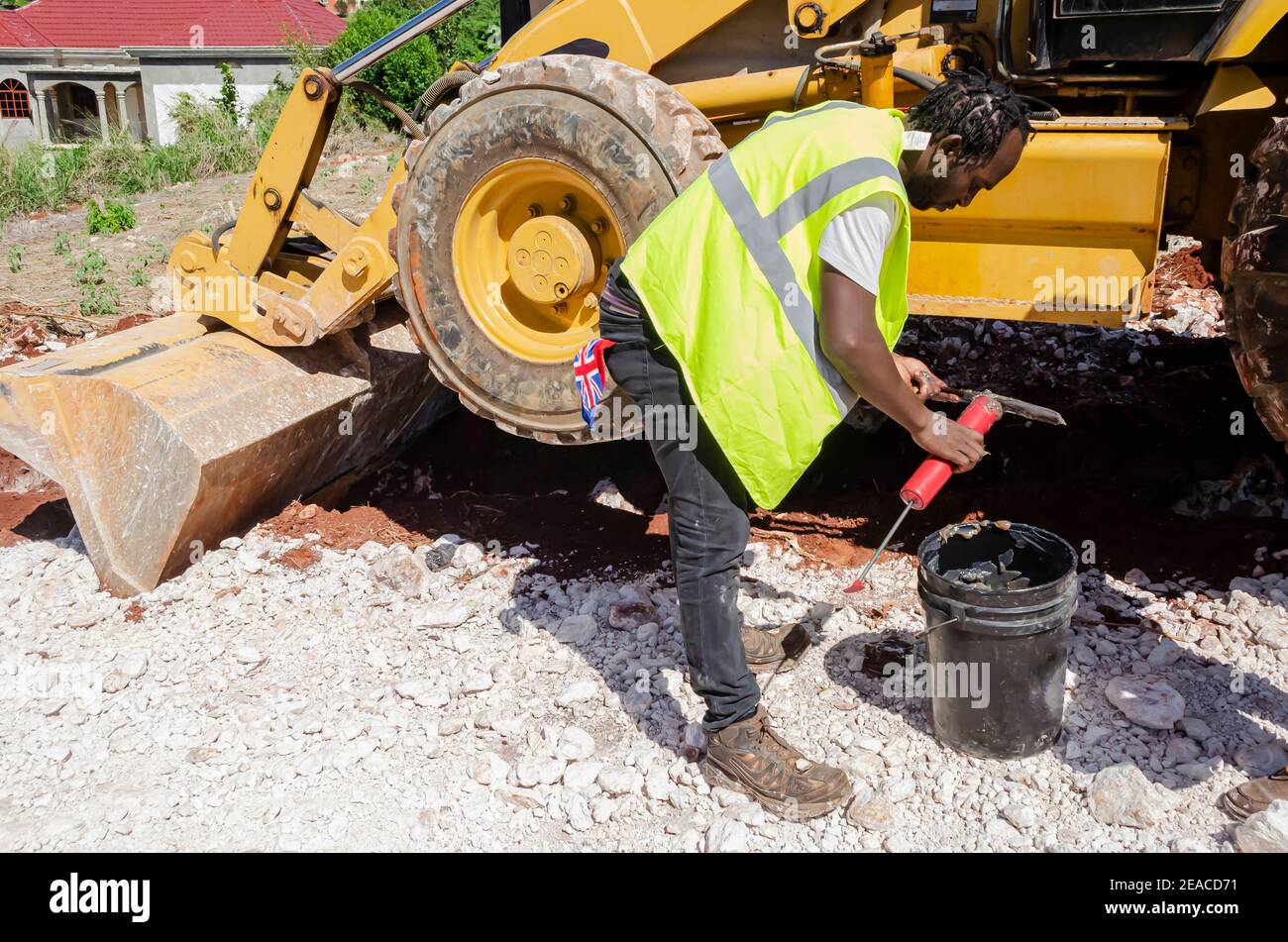 Equipment Operator Filling Grease Pump With Grease. Stock Photo