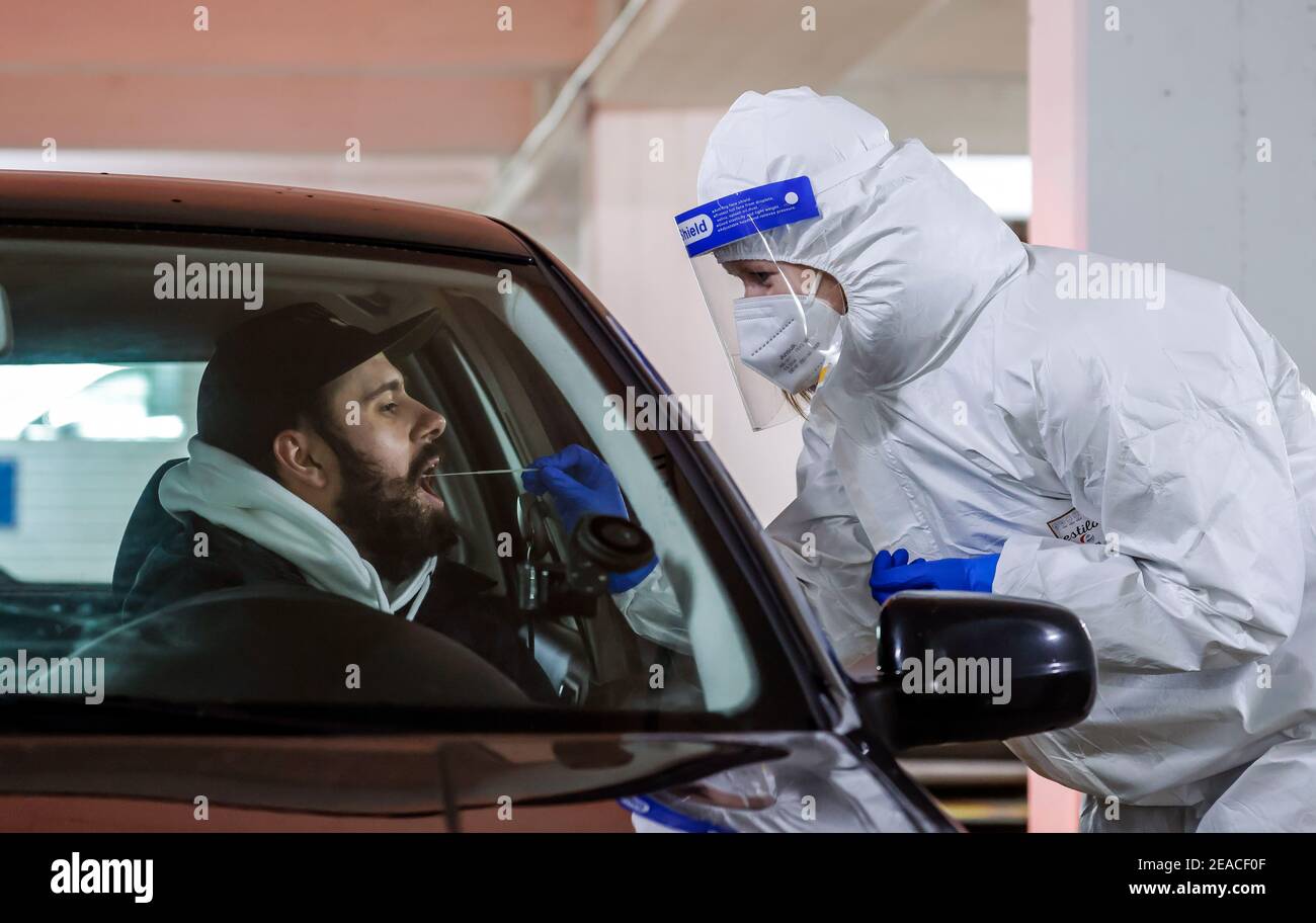 Cologne, North Rhine-Westphalia, Germany - Covid rapid test in a parking garage, at the Medicare test center, customers drive in the car at the drive-in counter for sampling (posed scene) Stock Photo