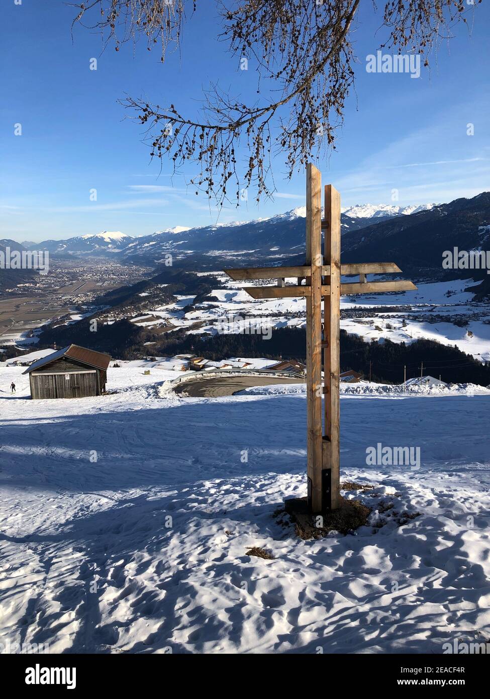 Wooden cross at Rangger Köpfl, view into the Inn Valley, snow, winter, Stiglreith, Oberperfuss, Tyrol, Austria Stock Photo