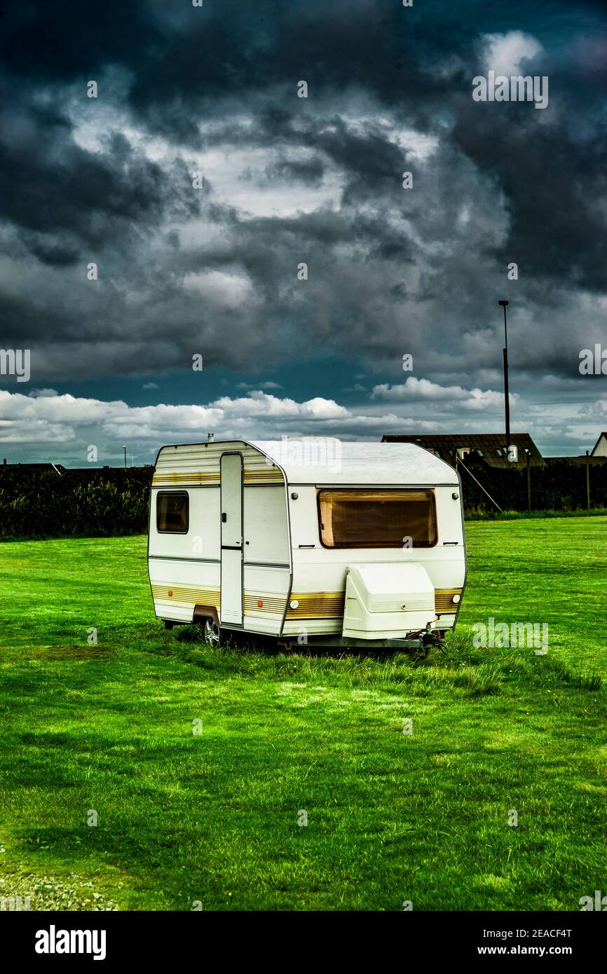 Old caravan in a meadow Stock Photo