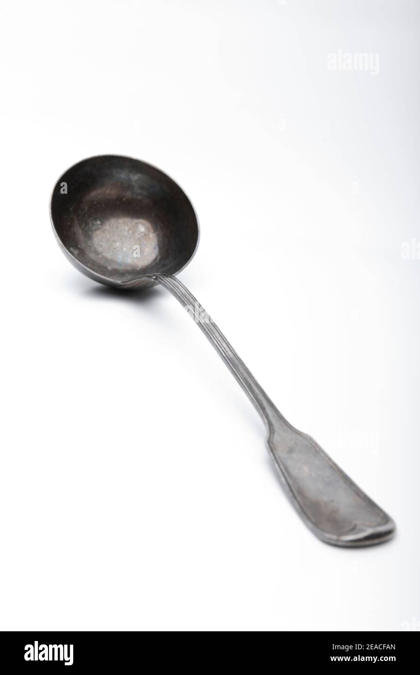 Old silver ladle against a white background Stock Photo