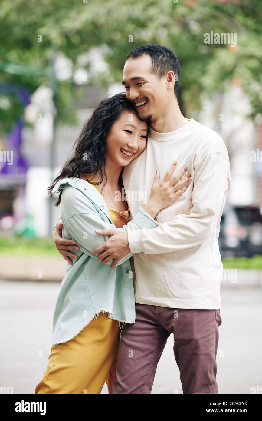 Woman hugging boyfriend Stock Photo - Alamy