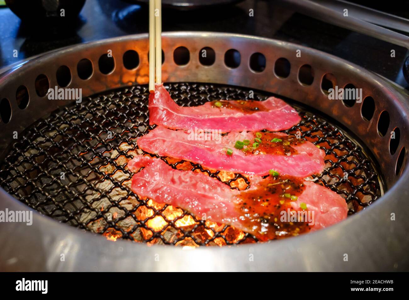 https://c8.alamy.com/comp/2EACHWB/close-up-raw-beef-slice-on-the-grill-over-charcoal-on-stovejapanese-style-yakiniku-2EACHWB.jpg