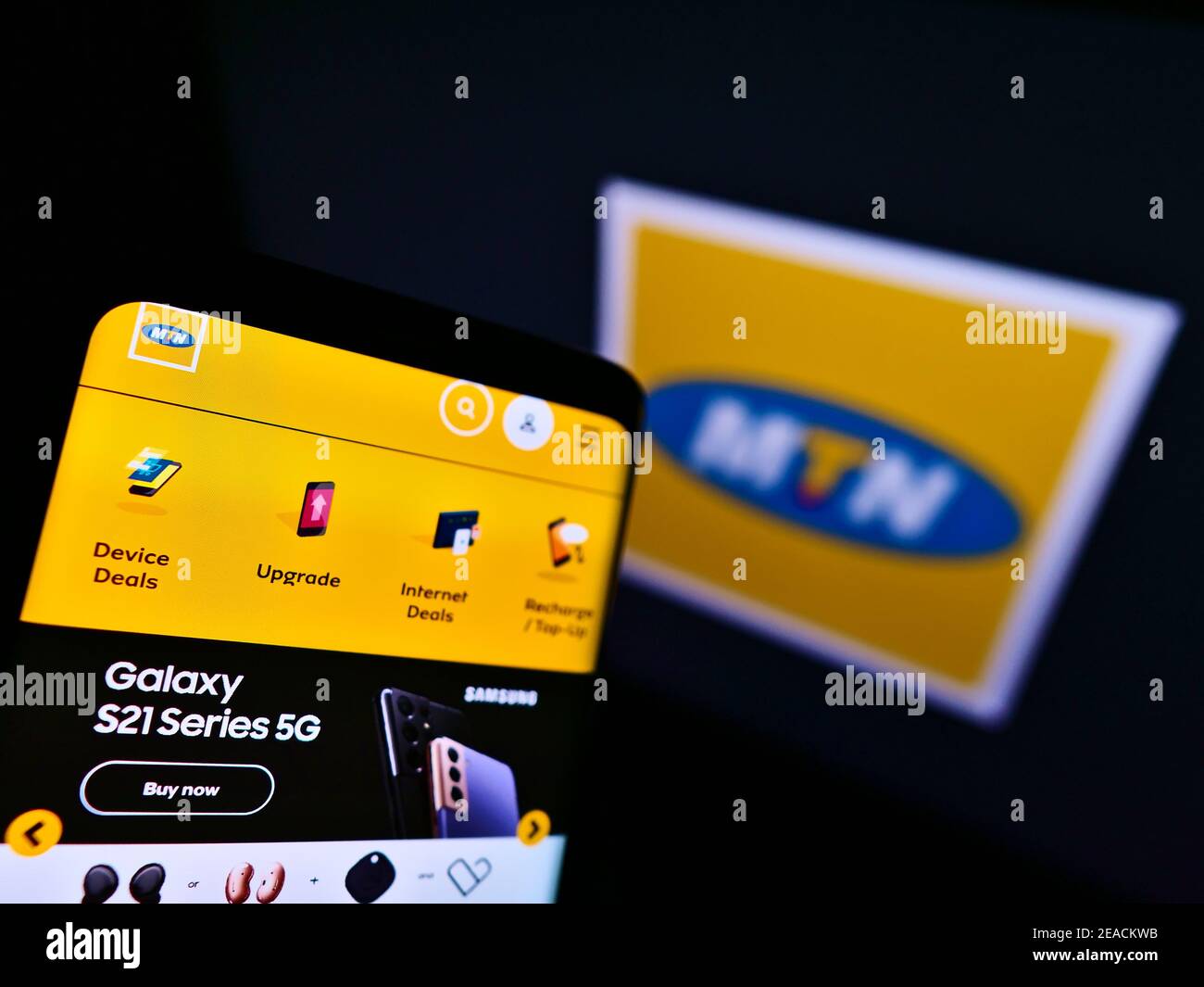 Mobile phone with website of South African telecommunications company MTN Group on screen in front of logo. Focus on top-left of phone display. Stock Photo