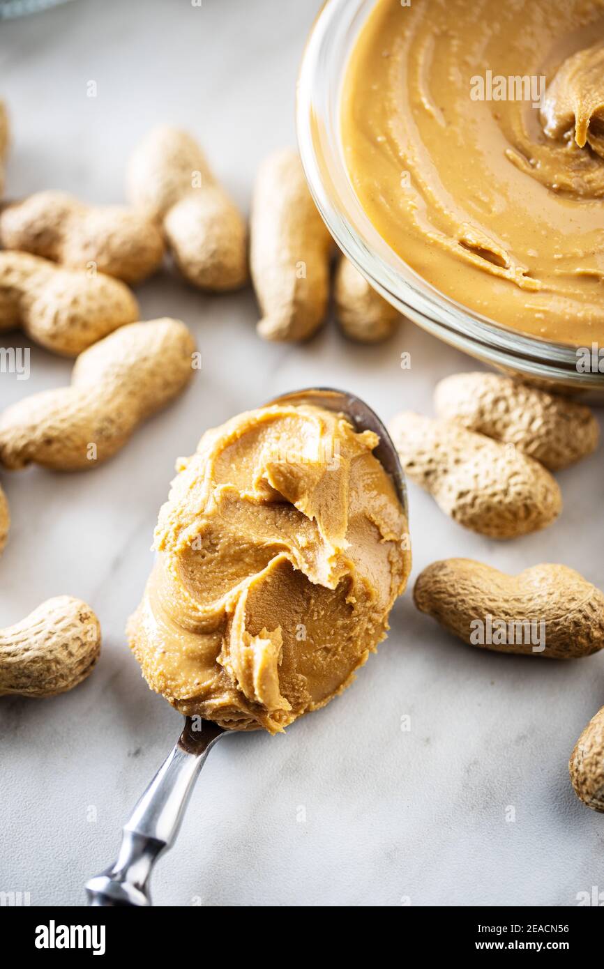 Peanut butter on spoon and peanuts Stock Photo Alamy