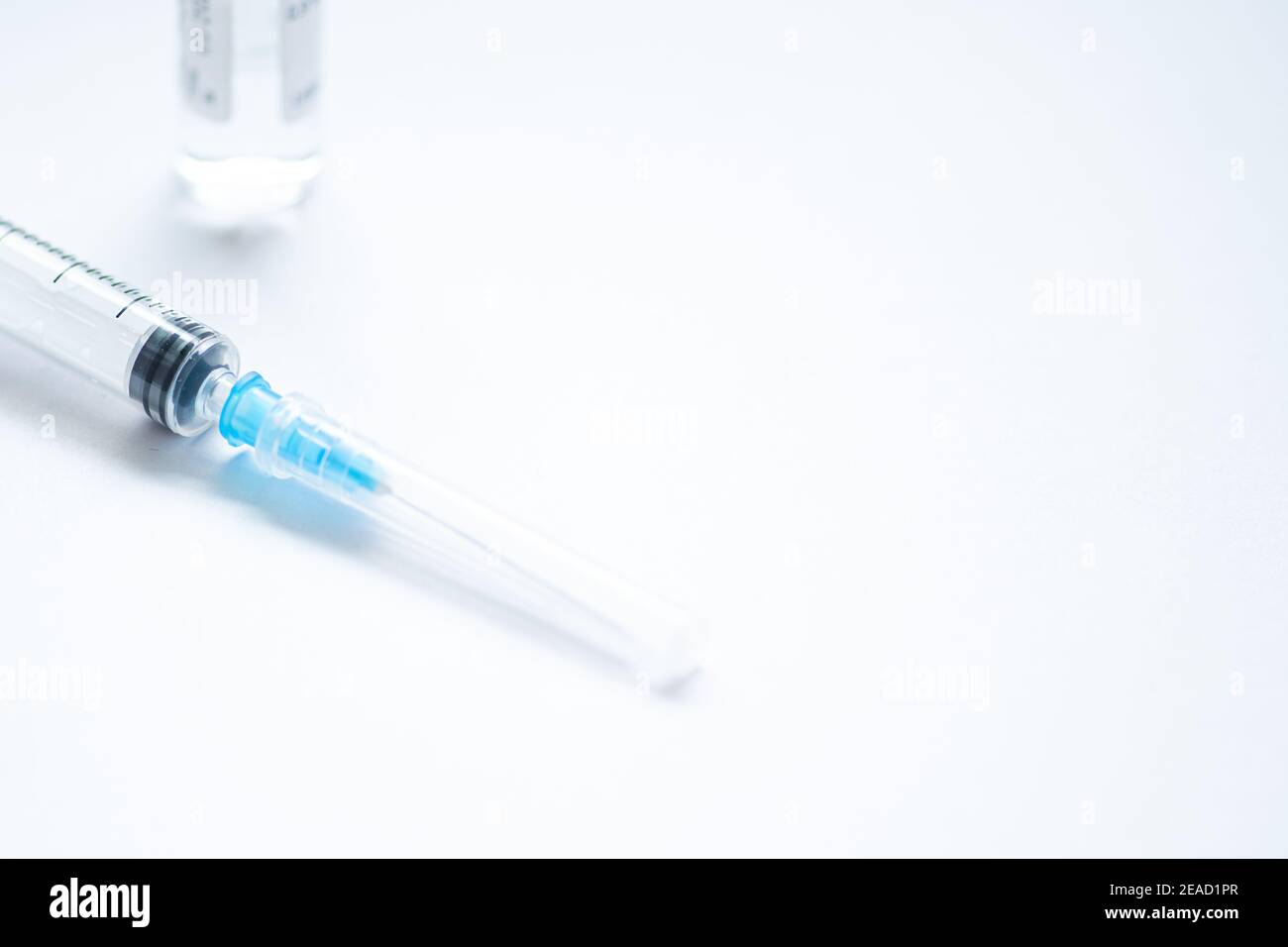 Syringe with needle and cover or top, vial or phial on a white empty space background ready to be used. Covid or Coronavirus vaccine or monoclonal Stock Photo