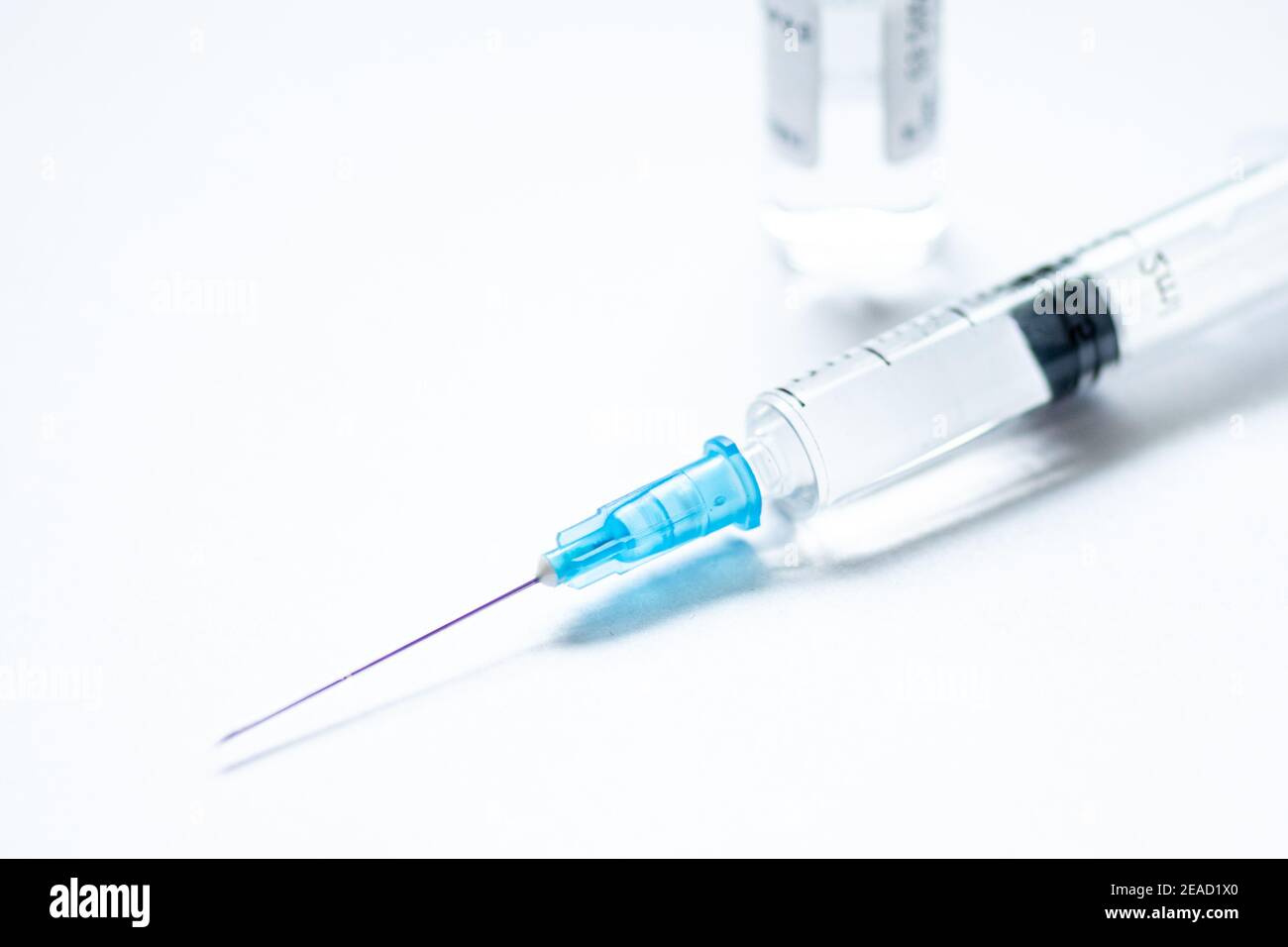 Syringe with needle without cover or top, vial or phial on a white empty space background ready to be used. Covid or Coronavirus vaccine or monoclonal Stock Photo