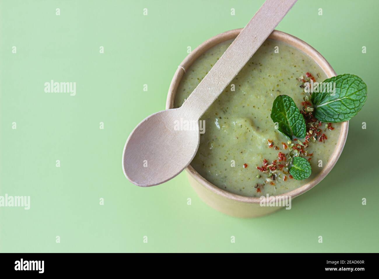 Vegetarian green cream soup in craft container for take away food
