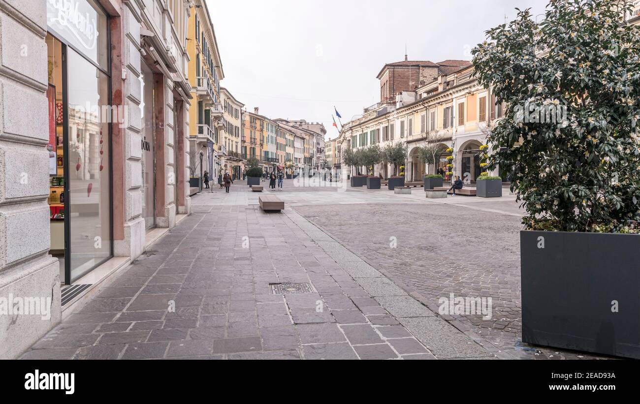 BRESCIA, ITALY - february 02 2021: cityscape with almost empty pedestrian precinct and historical buildings on Zanardelli square in town center, shot Stock Photo