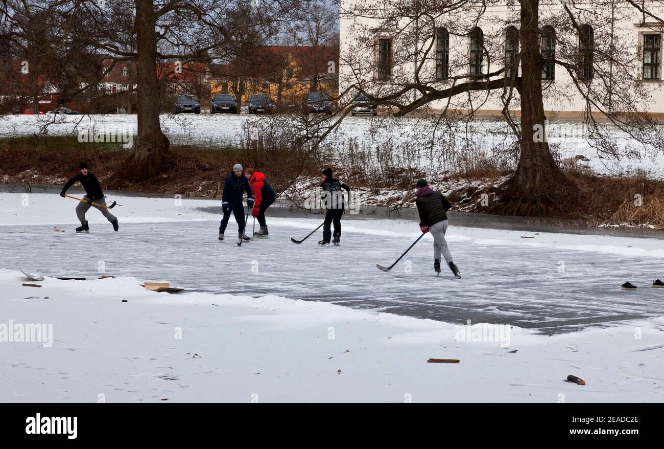 Hørsholm, Denmark, 8th February, 2021. Five young friends have cleared the ice for snow and enjoy a refreshing ice hockey match on the frozen lake. It is a rare and welcome healthy exercise and pastime in these Corona lockdown times, where all indoor sport facilities are closed. The Palace Lake, Slotssøen, has reached the required ice thickness of more than 13 cm, and is now open for access and skating for the first time since 2012. Stock Photo