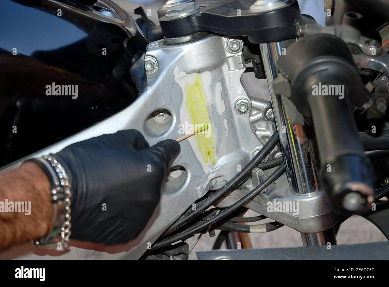 Scientific police with a swab and acid try to discover the hidden serial number of a motorcycle Stock Photo