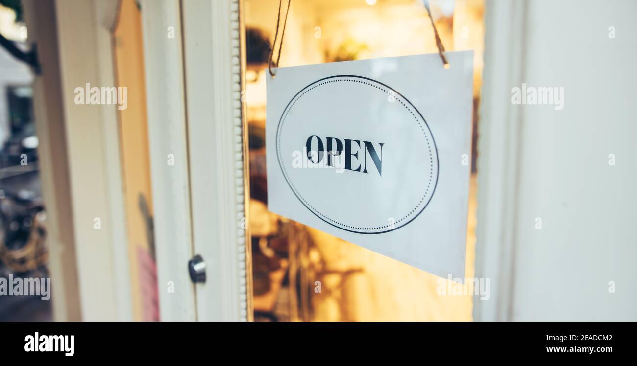Open sign hanging on store front door. Sign on storefronts announcing