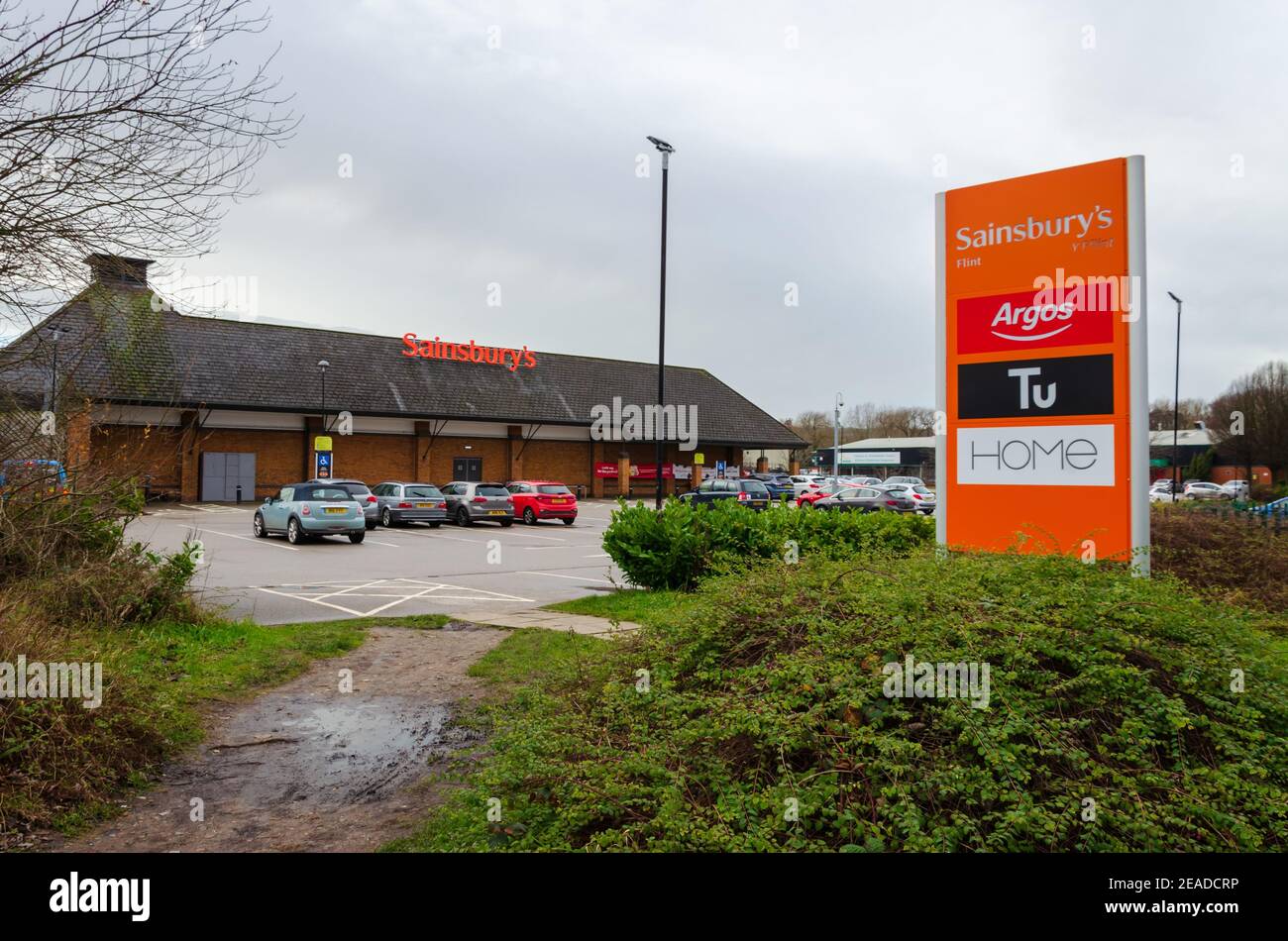 Flint; UK: Jan 28, 2021: Signage beside a Sainsbury's supermarket shows some of the instore brands, including Argos who recently relocated to inside t Stock Photo