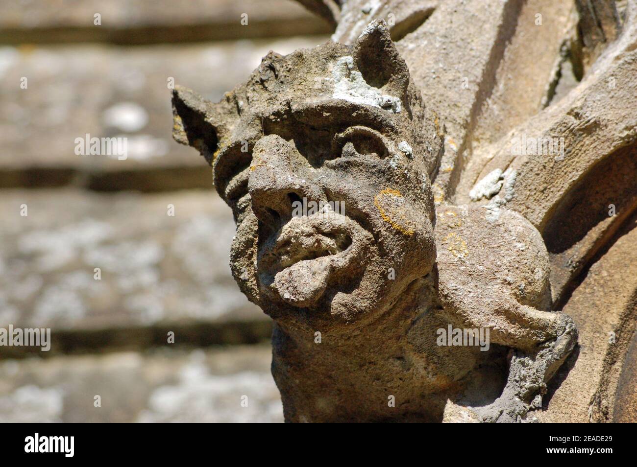 A stone gargoyle sticking out his tongue. Stone carving on a Victorian church in Berkshire Stock Photo